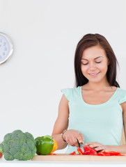 Smiling woman slicing a pepper