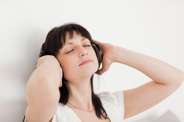 Naklejka premium Charming brunette woman relaxing with headphones while sitting o