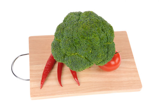 broccoli and tomato and red pepper on cutting board