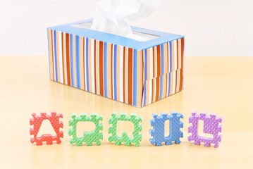April Spelled Out on Table with Box of Tissue