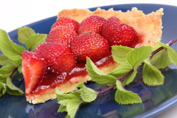 Piece of Strawberry Tart decorated with mint twigs