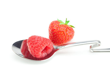 spoon, strawberries and raspberries isolated on white