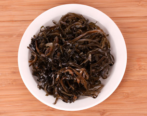 seaweed on plate on wooden background