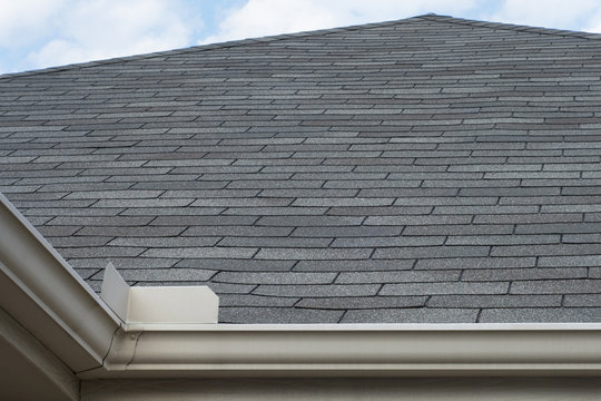 Rain Gutters Splash Guard On Roof Against Blue Sky