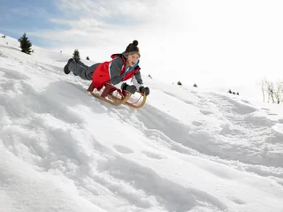 Fotobehang Pre-teen Boy On A Sled In The Snow © micromonkey
