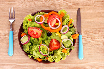 salad of fresh vegetables in a plate and cutlery
