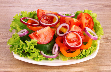 salad of fresh vegetables on the plate on wooden background