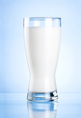 Glass of milk on blue background