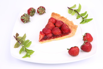 Piece of Strawberry Tart decorated with strawberries and mint