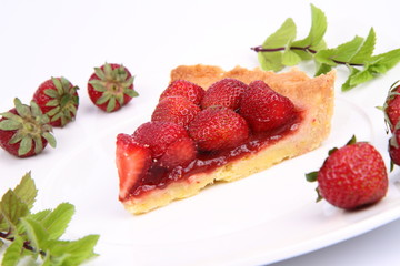 Piece of Strawberry Tart decorated with strawberries and mint