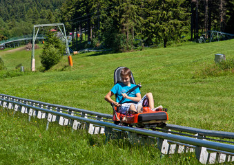 Sommer Rodelbahn Kind im Schlitten