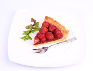Piece of Strawberry Tart decorated with mint twig and a fork