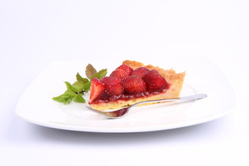 ce of Strawberry Tart on white plate decorated with mint twig