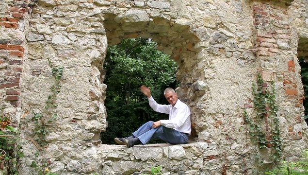 Sitzender Mann gr&uuml;&szlig;t