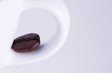 Obraz premium Chicco di caffè su manico tazzina