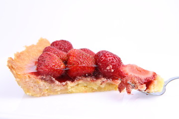 Strawberry Tart portion, a bite on a fork, on a white