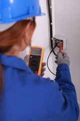 Female electrician using a voltmeter