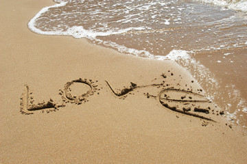 The inscription "love" on the sea sand