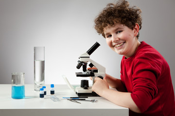 Boy examining preparation under the microscope