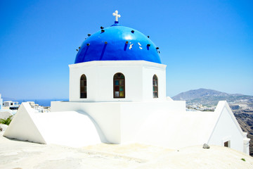 white washed church with blue dome in santorini island