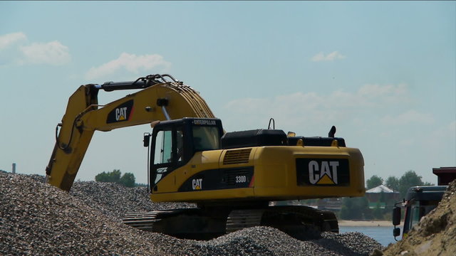 Yellow excavator loading gravel