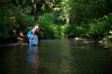 Fototapeta premium beautiful girl touches the water