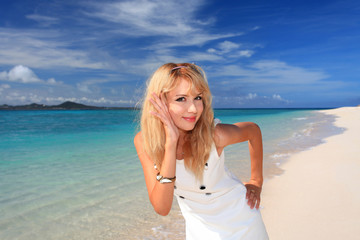 Fototapeta na wymiar 砂浜で寛いでいる笑顔の女性