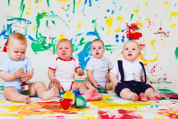 Babies with paints and paintbrushes