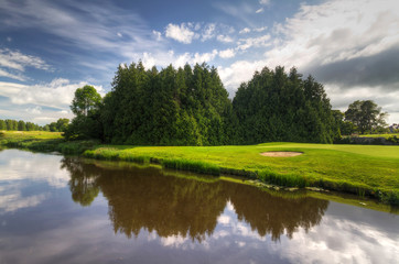 Idyllic golf course with reflection in the river