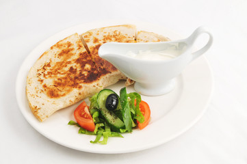 Baked flat cake with a garnish and sauce