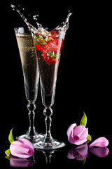 Two glasses of sparkling splashing wine (champagne) and roses