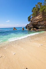 View from a sandy beach on rocks at ocean.Indonesia,Bali..