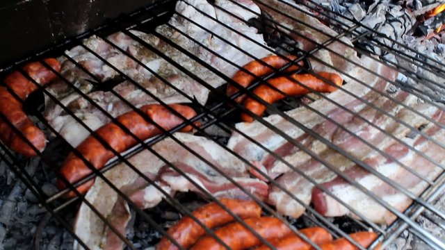 poniendo la parrilla con carne en el fuego