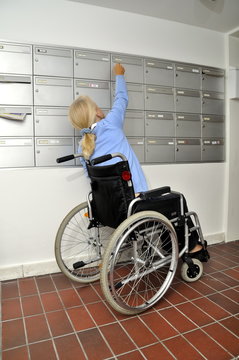 Behinderte Frau am Postkasten