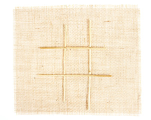 Sackcloth with Tic Tac Toe game pattern with straws on burlap