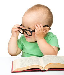 Little child play with book and glasses