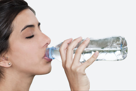 Mujer joven bebiendo agua ojos cerrados