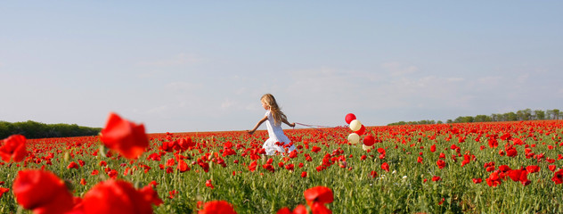 young girl running in poppy field