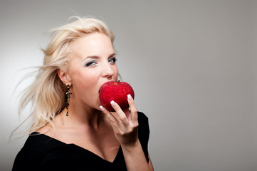 Blonde woman biting red apple