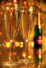 Champagne in glasses and lights on gold background.