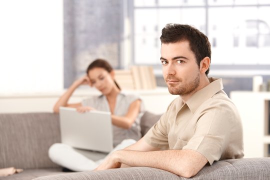 Young couple sitting on sofa at home