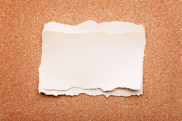 ripped piece of paper on cork board background