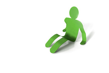 Green paper man sitting on a floor