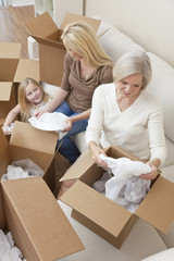 Fototapeta na wymiar Female Generations of Family Unpacking Boxes Moving House