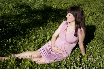 Naklejka na ściany i meble young pregnant girl in park
