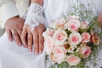 Obraz na płótnie Canvas Ręce i pierścienie z bukiet ślubny