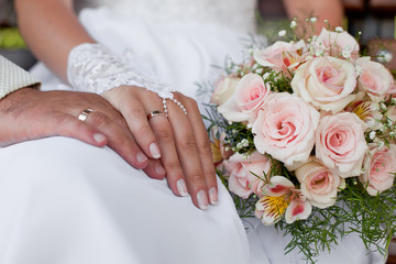 Obraz na płótnie Canvas Hands and rings with wedding bouquet