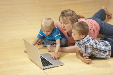 Family watching laptop on the floor