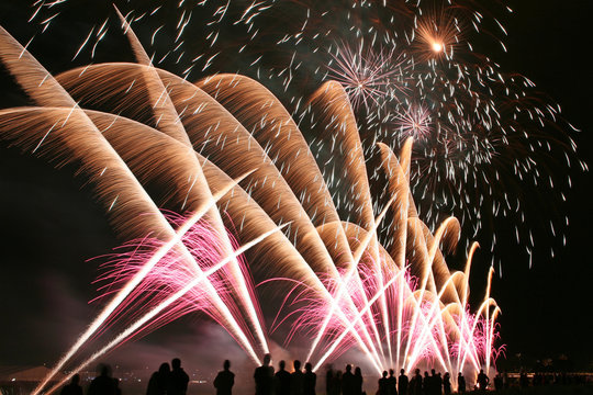 Fireworks in the amusement park with people in front