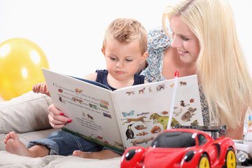 a mother and her baby looking a book